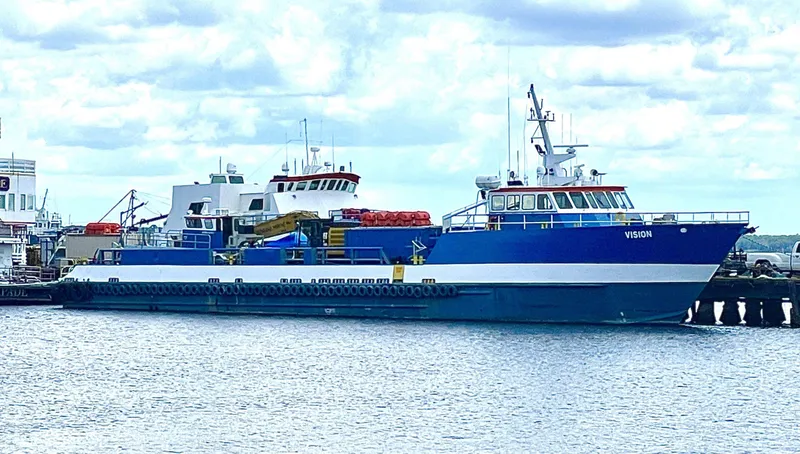 Slide: The Image of Custom Offshore Supply Vessel, 2002, docked at a harbor under a cloudy sky. - 17