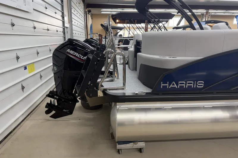 Slide: The Image of 2026 Harris Cruiser 210 CWDH pontoon boat with Mercury outboard motor in a garage. - 14