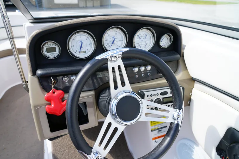 Slide: The Image of Steering wheel and dashboard of 2007 Four Winns 210 Horizon boat, featuring gauges and controls. - 12