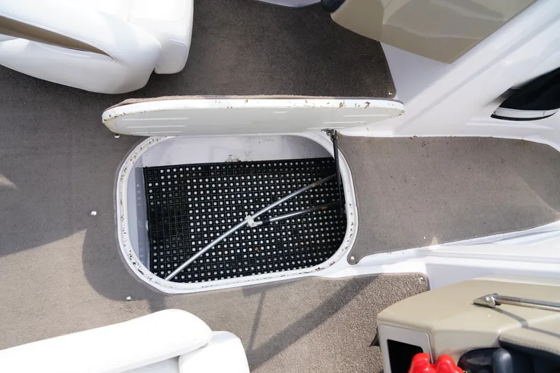 Slide: The Image of 2007 Four Winns 210 Horizon boat storage compartment with open hatch and carpeted flooring. - 18