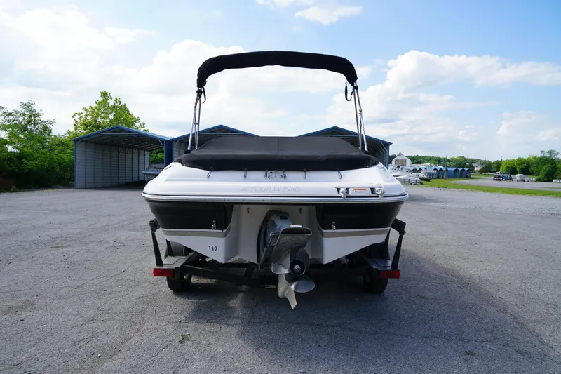 Slide: The Image of 2007 Four Winns 210 Horizon boat on trailer, parked outdoors under a clear sky. - 4
