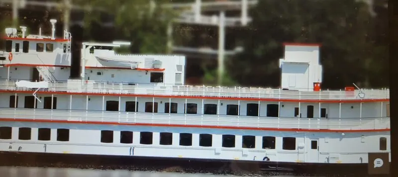 Slide: The Image of White 1985 custom dinner excursion passenger boat with red trim on a river. - 1