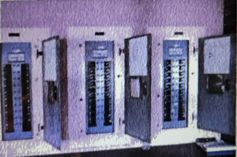 Slide: The Image of Vintage 1985 electrical control panels with open doors in a dimly lit room. - 21