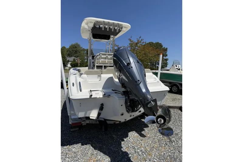 Slide: The Image of 2026 Key West 219 FS boat with outboard motor, parked on gravel. - 5
