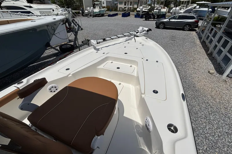 Slide: The Image of 2026 Key West 250 Bay Reef boat with brown seating, parked in a gravel lot. - 11