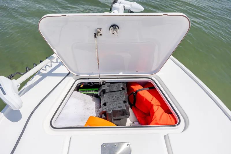 Slide: The Image of Open storage compartment on 2018 Bomb Island 160 SC boat with life jacket and battery. - 19