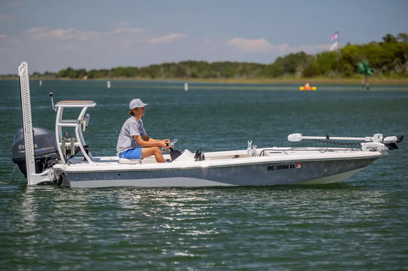 Slide: The Image of 2018 Bomb Island 160 SC boat on calm water with a person steering. - 2