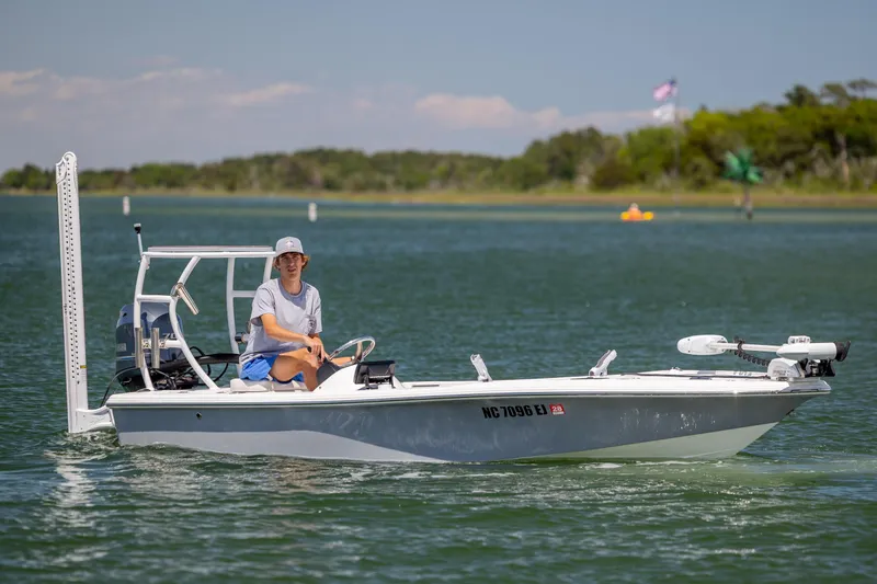 Slide: The Image of 2018 Bomb Island 160 SC boat on water with person steering, scenic background. - 7
