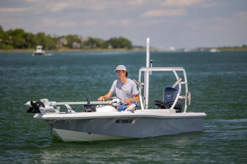 Slide: The Image of Person piloting a 2018 Bomb Island 160 SC boat on a calm lake. - 8