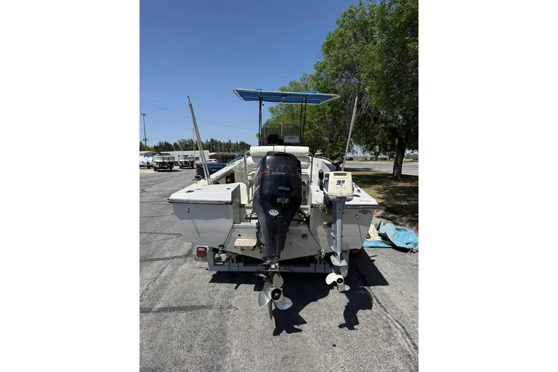 Slide: The Image of 1985 Wellcraft 180 Fisherman boat with dual outboard motors, parked outdoors. - 4