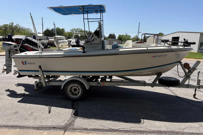 Slide: The Image of 1985 Wellcraft 180 Fisherman boat on trailer, parked outdoors under clear sky. - 5