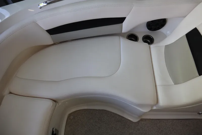 Slide: The Image of 2009 Chaparral Sunesta 244 boat interior with white cushioned seating and cup holders. - 10