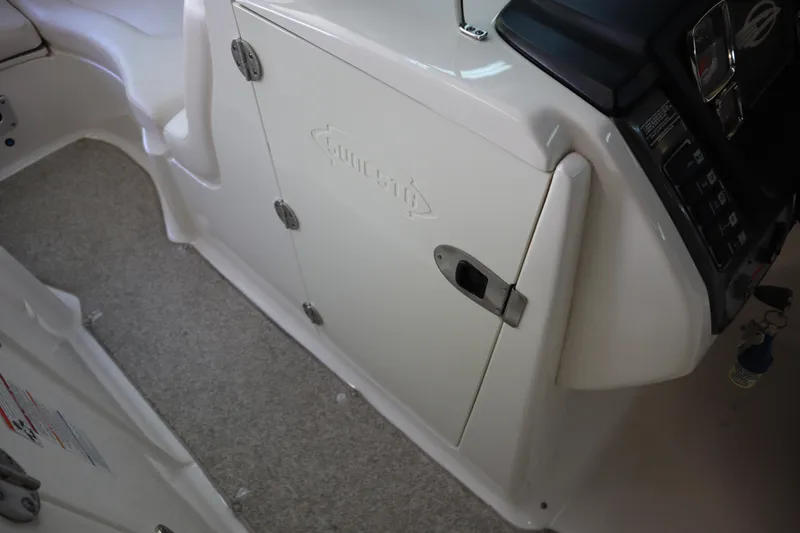 Slide: The Image of 2009 Chaparral Sunesta 244 boat interior, featuring storage compartment and control panel. - 12