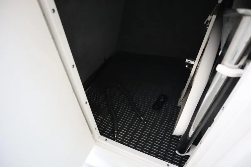Slide: The Image of Storage compartment in 2009 Chaparral Sunesta 244 boat, featuring black flooring and equipment. - 15