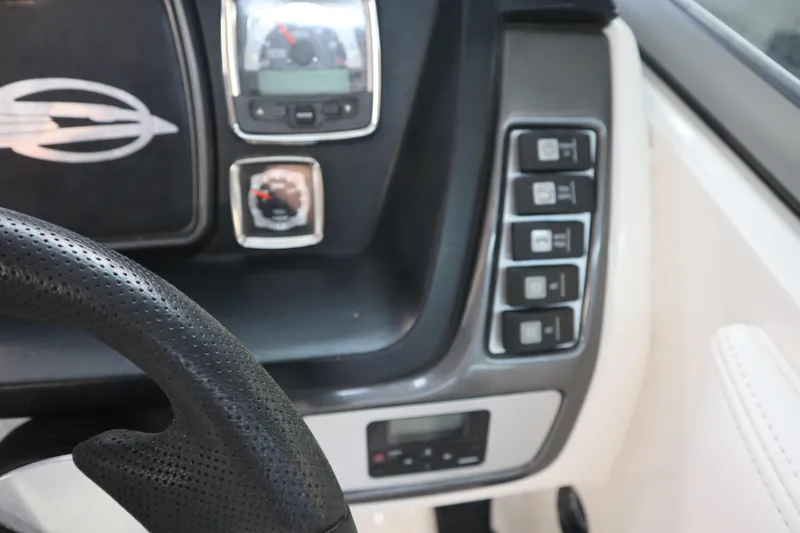 Slide: The Image of Dashboard controls of a 2009 Chaparral Sunesta 244 boat, featuring steering wheel and gauges. - 17
