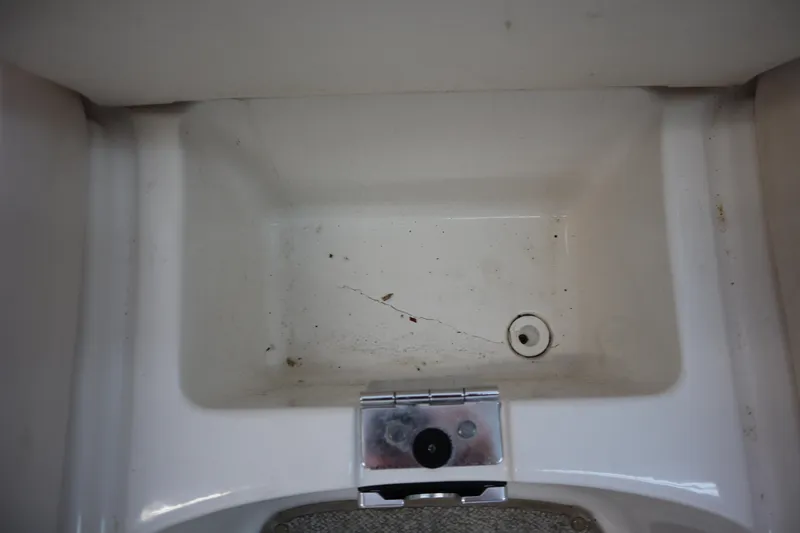 Slide: The Image of 2009 Chaparral Sunesta 244 boat sink with drain, showing minor dirt and debris. - 9