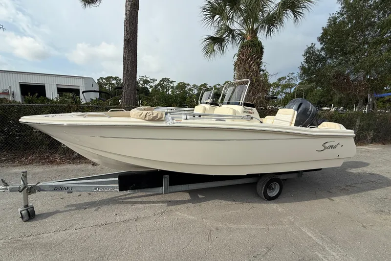 The Image of 2026 Scout 188 Sport Dorado boat on trailer, parked outdoors near trees. - 0
