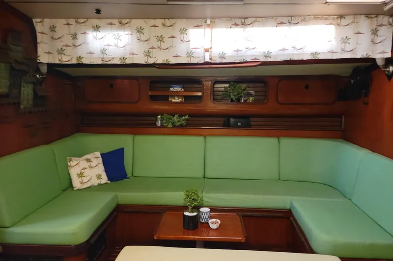 Slide: The Image of Interior of 1986 Beneteau Idylle 15.50 yacht with green seating and tropical decor. - 12