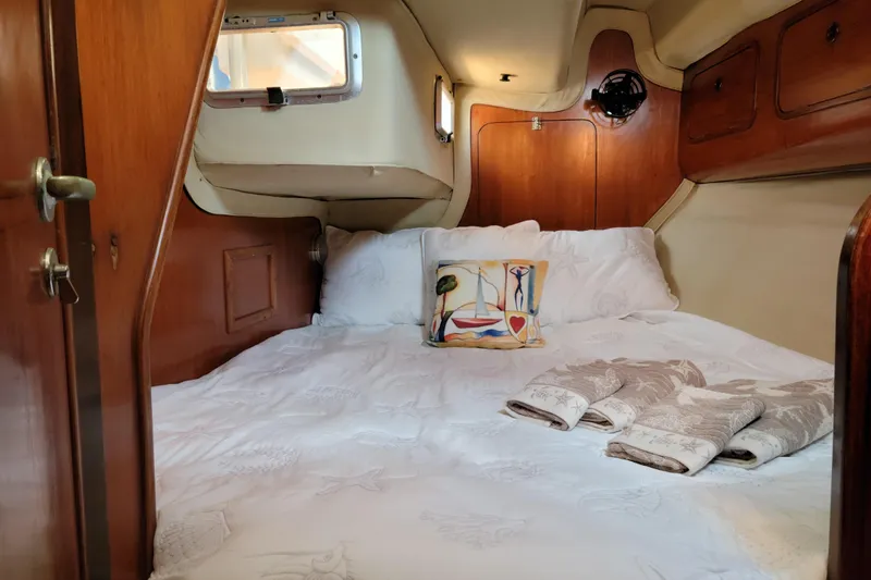 Slide: The Image of Cozy cabin interior of 1986 Beneteau Idylle 15.50 sailboat with bed and nautical decor. - 15