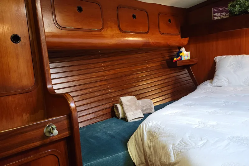 Slide: The Image of Cozy cabin interior of 1986 Beneteau Idylle 15.50 sailboat with wooden accents and bedding. - 18