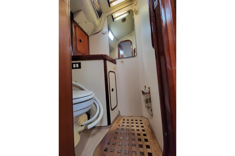 Slide: The Image of 1986 Beneteau Idylle 15.50 yacht bathroom with wooden accents and compact design. - 26