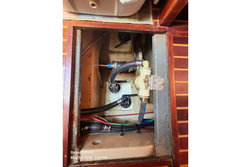 Slide: The Image of Bilge area of a 1986 Beneteau Idylle 15.50 sailboat, showing hoses and fittings. - 44