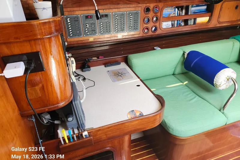 Slide: The Image of Interior of 1986 Beneteau Idylle 15.50 yacht with green seating and navigation equipment. - 46