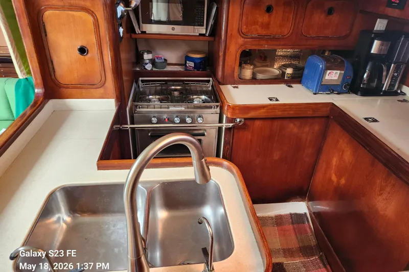 Slide: The Image of Galley kitchen in 1986 Beneteau Idylle 15.50 yacht with sink, stove, and appliances. - 49
