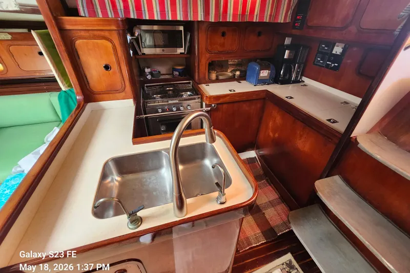 Slide: The Image of Cozy kitchen area in a 1986 Beneteau Idylle 15.50 sailboat with wooden cabinetry. - 50