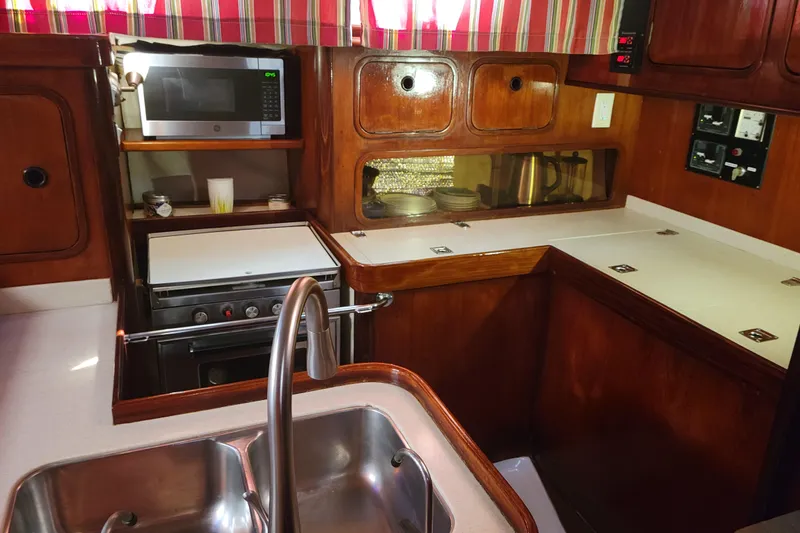 Slide: The Image of Galley kitchen in 1986 Beneteau Idylle 15.50 yacht with wood cabinetry and modern appliances. - 6