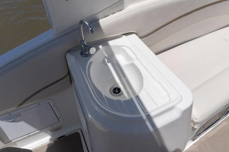 Slide: The Image of 2005 Larson Cabrio 290 boat interior with sink and seating area. - 10