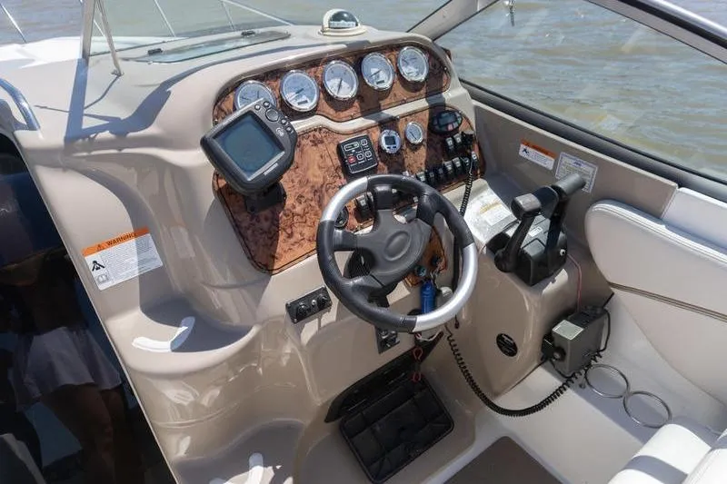 Slide: The Image of 2005 Larson Cabrio 290 boat dashboard with steering wheel and navigation instruments. - 11