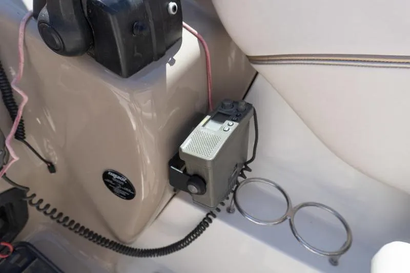 Slide: The Image of 2005 Larson Cabrio 290 boat interior with radio and cup holders. - 13