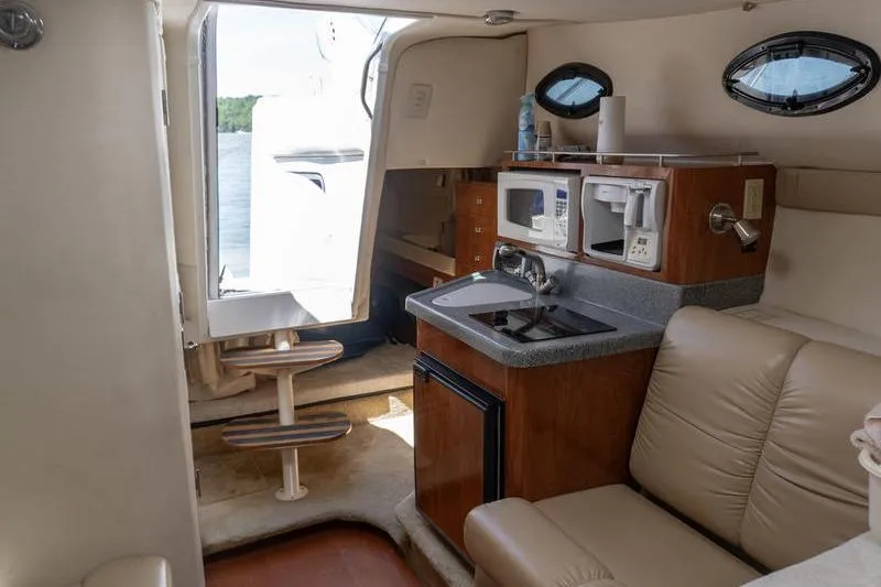 Slide: The Image of Interior of a 2005 Larson Cabrio 290 boat with kitchenette and seating area. - 15