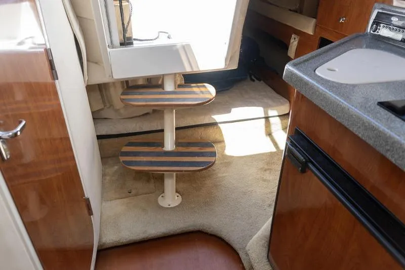 Slide: The Image of Interior of 2005 Larson Cabrio 290 boat with wooden steps and kitchenette. - 17