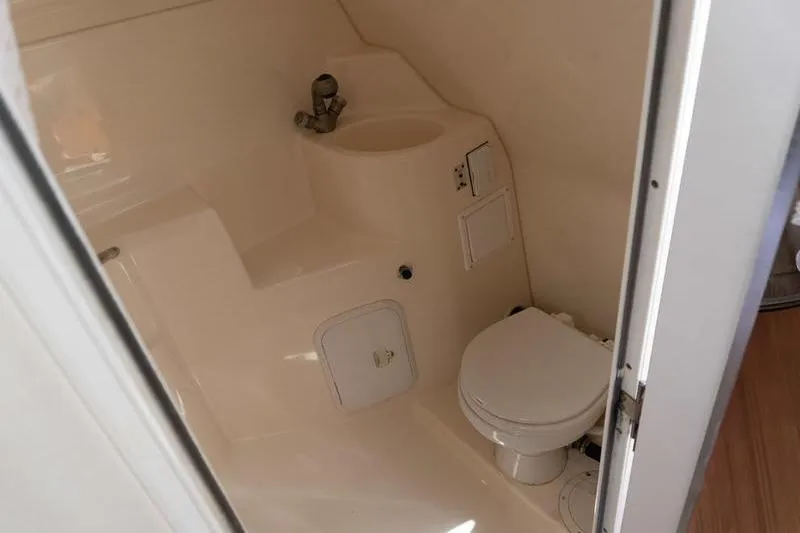 Slide: The Image of 2005 Larson Cabrio 290 boat bathroom with toilet and sink. - 21