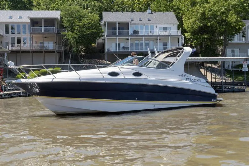 Slide: The Image of 2005 Larson Cabrio 290 boat on a lake, with waterfront homes in the background. - 3