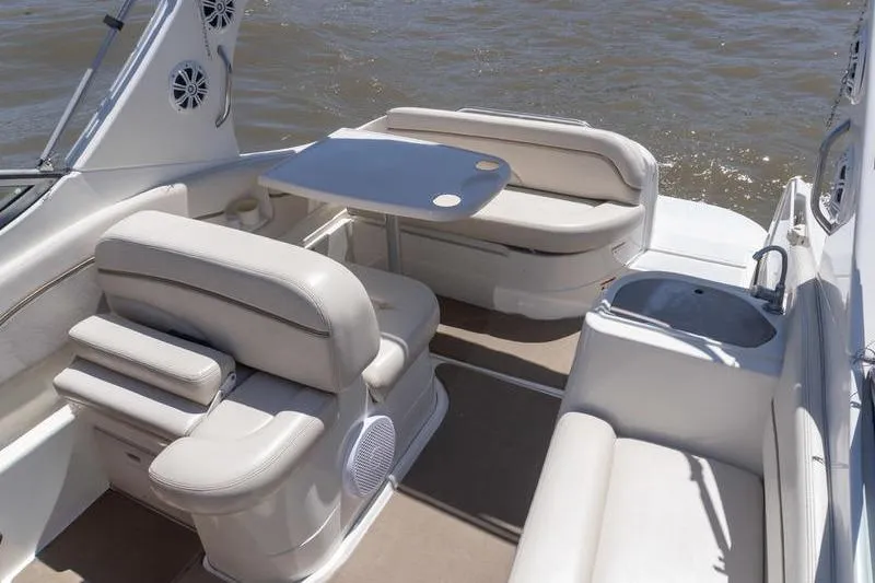 Slide: The Image of 2005 Larson Cabrio 290 boat interior with seating and table on water. - 6