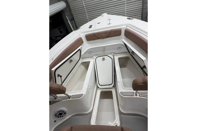 Slide: The Image of 2019 Sea Hunt Gamefish 25 boat interior with open storage compartments and cushioned seating. - 10