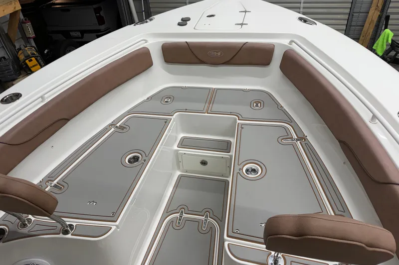 Slide: The Image of 2019 Sea Hunt Gamefish 25 boat interior with cushioned seating and storage compartments. - 11