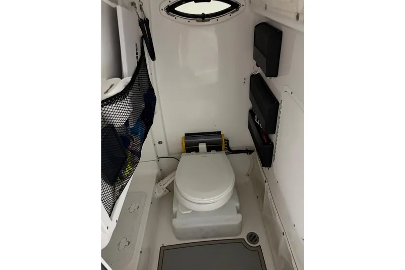 Slide: The Image of Interior of 2019 Sea Hunt Gamefish 25 boat featuring a compact marine toilet. - 12