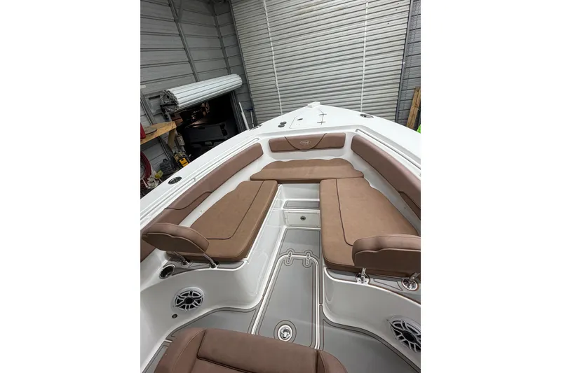 Slide: The Image of 2019 Sea Hunt Gamefish 25 boat interior with brown seating in a garage. - 15