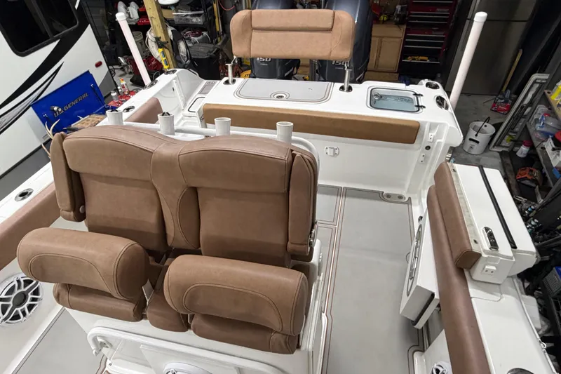 Slide: The Image of 2019 Sea Hunt Gamefish 25 boat interior with tan seating and fishing rod holders. - 17