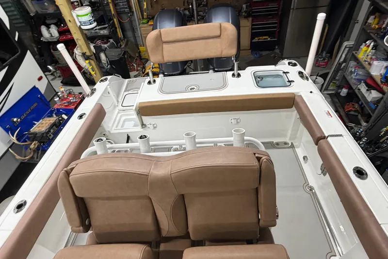 Slide: The Image of 2019 Sea Hunt Gamefish 25 boat interior with tan seating and fishing rod holders. - 18