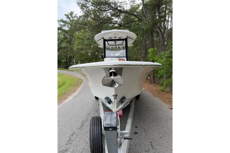 Slide: The Image of 2019 Sea Hunt Gamefish 25 boat on trailer, surrounded by trees. - 2