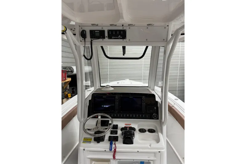 Slide: The Image of 2019 Sea Hunt Gamefish 25 boat console with steering wheel and navigation equipment. - 22