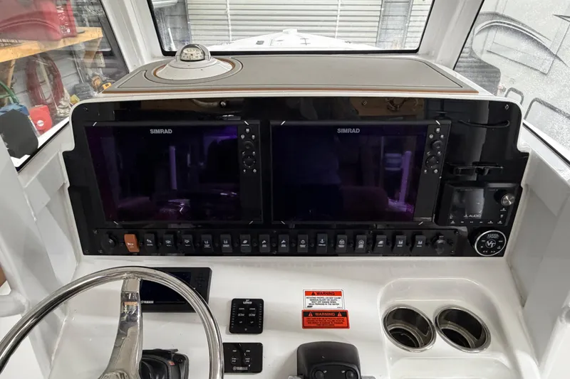 Slide: The Image of 2019 Sea Hunt Gamefish 25 dashboard with dual Simrad displays and control panel. - 23
