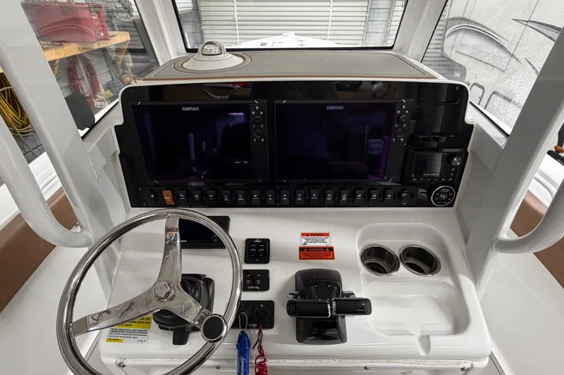 Slide: The Image of 2019 Sea Hunt Gamefish 25 helm with dual Simrad displays and stainless steel steering wheel. - 24