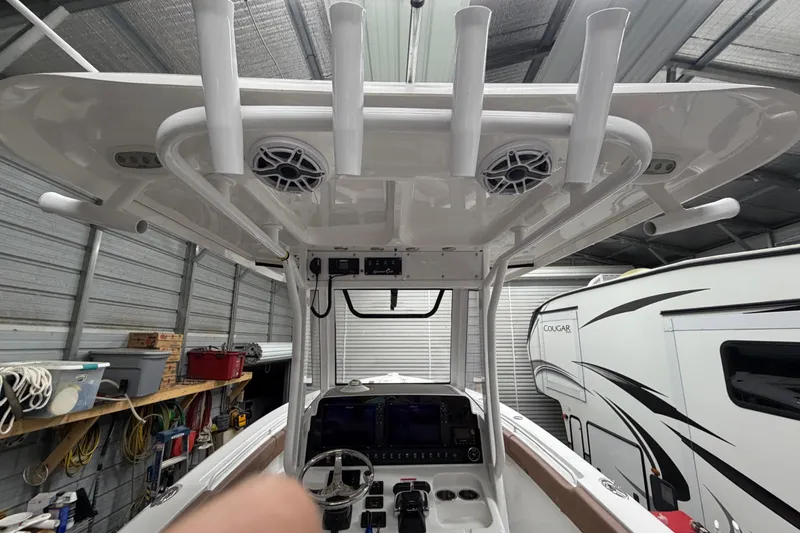 Slide: The Image of 2019 Sea Hunt Gamefish 25 boat interior with rod holders and electronics in a garage setting. - 25