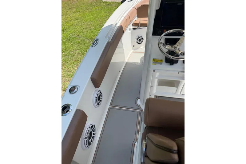Slide: The Image of 2019 Sea Hunt Gamefish 25 boat interior with brown seating and steering wheel. - 5
